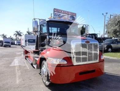 Peterbilt 337 rollback truck front view showing chrome grille, red lower body, and black cab with side mirrors.
