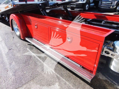 Peterbilt 337 rollback truck side toolbox and red-painted side panel with storage compartments and steps visible.