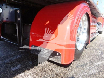 Peterbilt 337 rollback truck side view showing red fender and wheel, part of the chassis visible.