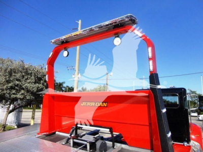 Peterbilt 337 rollback truck with red bed and overhead warning light bar, side window, stock number J04652 label visible.
