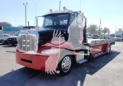 Peterbilt 337 rollback truck front-left view with blue cab and red bumper, chrome grille, and long flatbed.