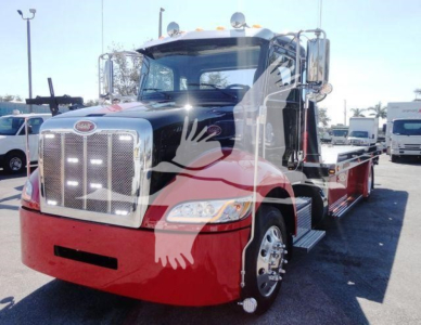 Peterbilt 337 rollback truck front-left view showing chrome grille, dual mirrors, red lower bumper, and black cab with chrome steps.