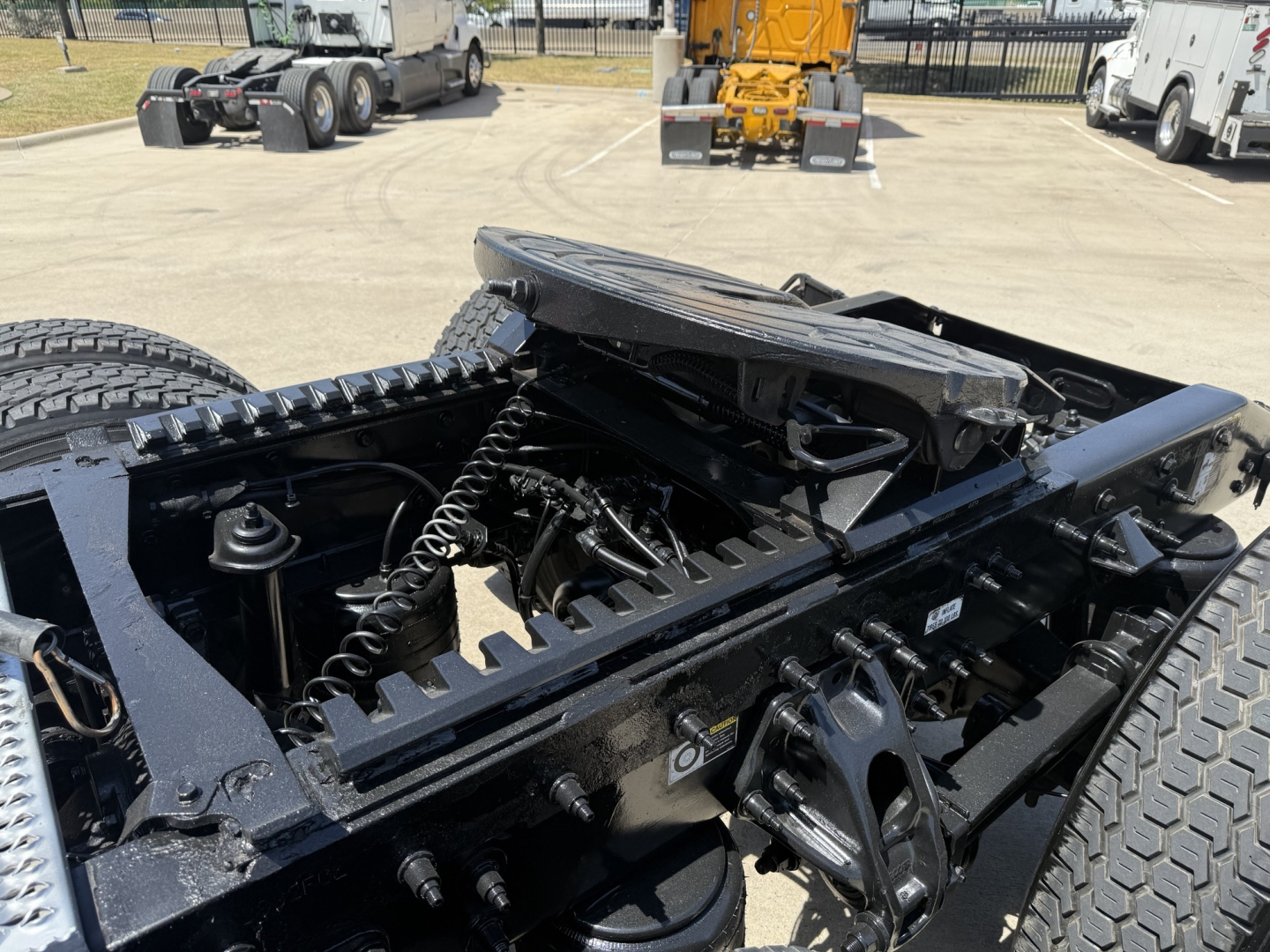 Peterbilt 579 truck chassis and fifth wheel area with exposed underframe and suspension components, 2023 model, in a dealership lot.