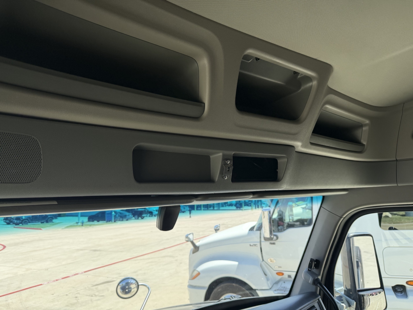 Peterbilt 579 cab interior front dash view showing overhead compartments and sun visor area.