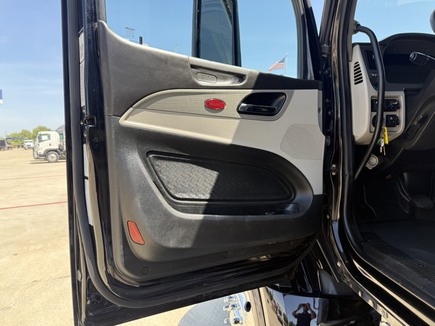 Peterbilt 579 interior – driver door open showing door panel and dashboard area with gray and black trim