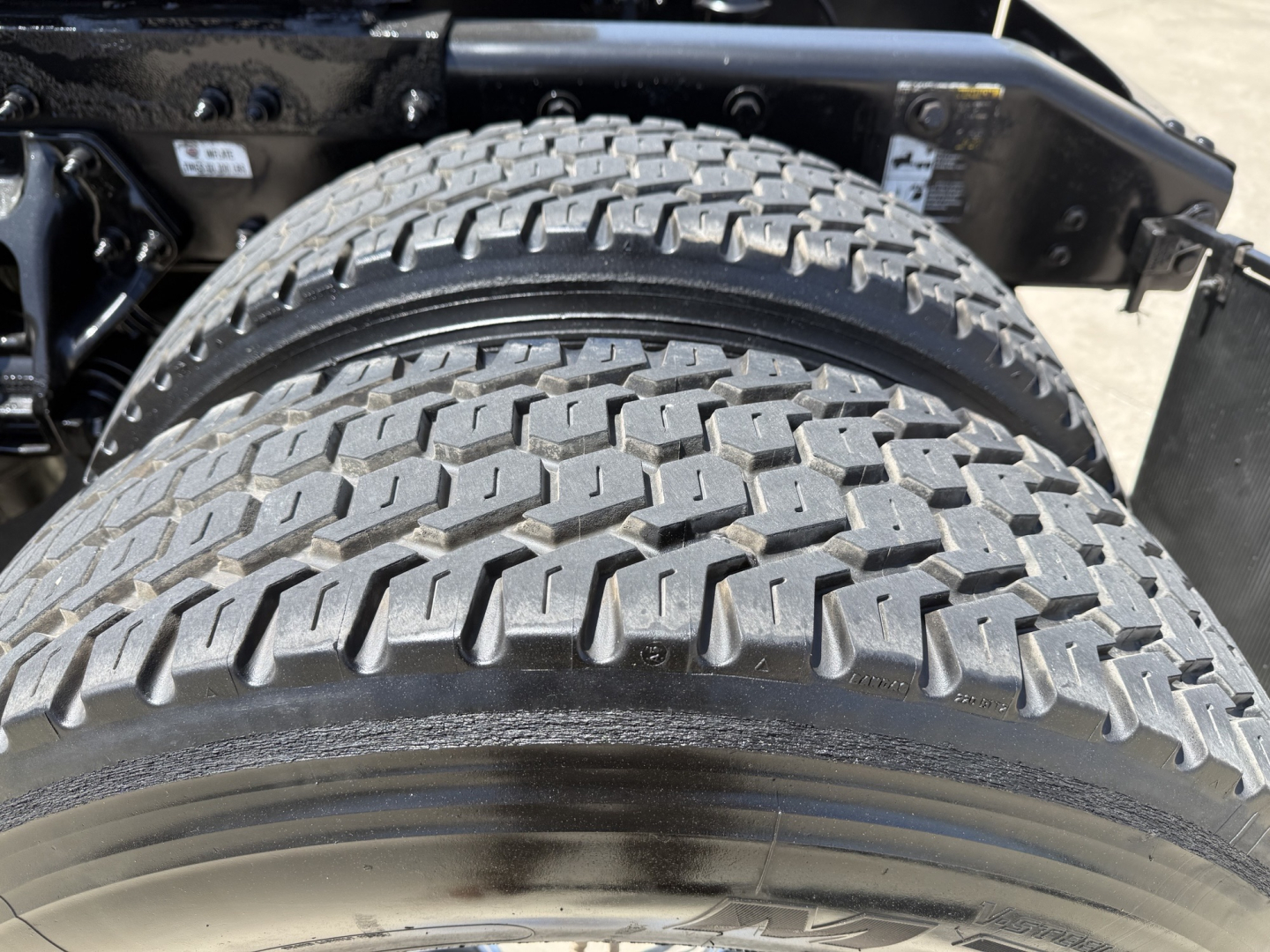 Peterbilt 579 wheel/tire close-up showing dual rear axle tires and suspension mounting.
