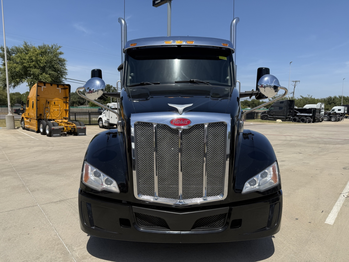 Peterbilt 579 front view showing chrome grille, large bumper, and side mirrors; blue cab with Peterbilt emblem