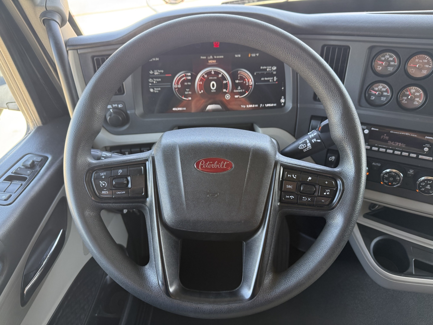 Peterbilt steering wheel and dashboard in a 2023 Peterbilt 579 showing digital instrument cluster and steering controls.