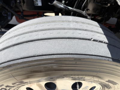 Peterbilt 579 front tire and wheel well as seen from side angle; tread details visible with wheel and undercarriage components