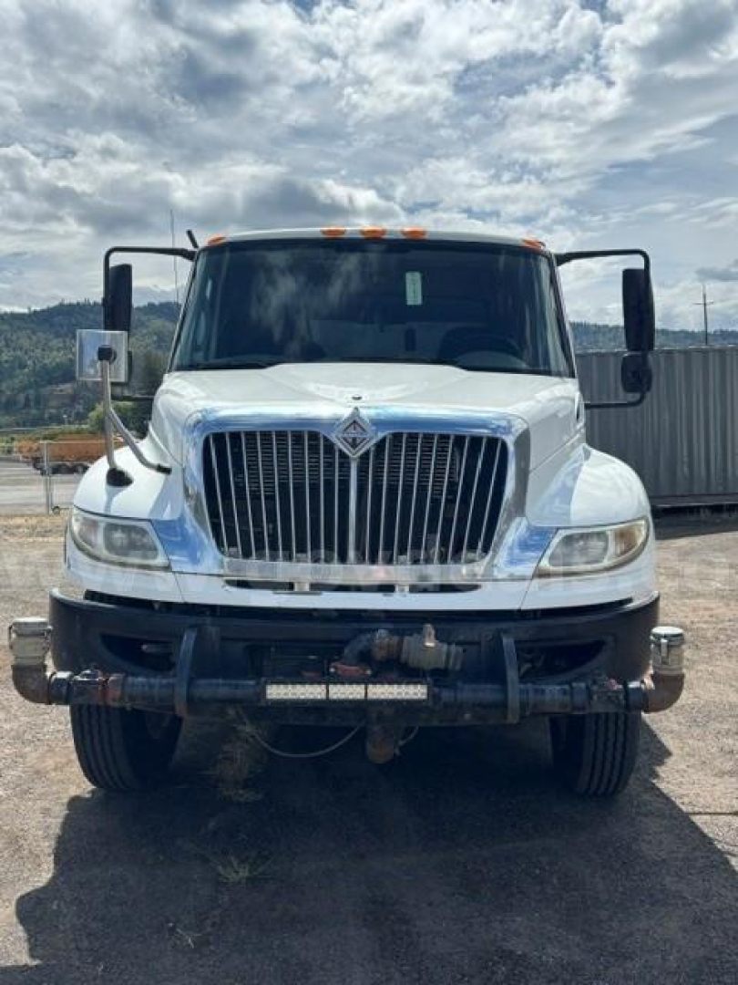 Front view of a white 2010 International 4400 truck showing grille, bumper, and dual side mirrors.