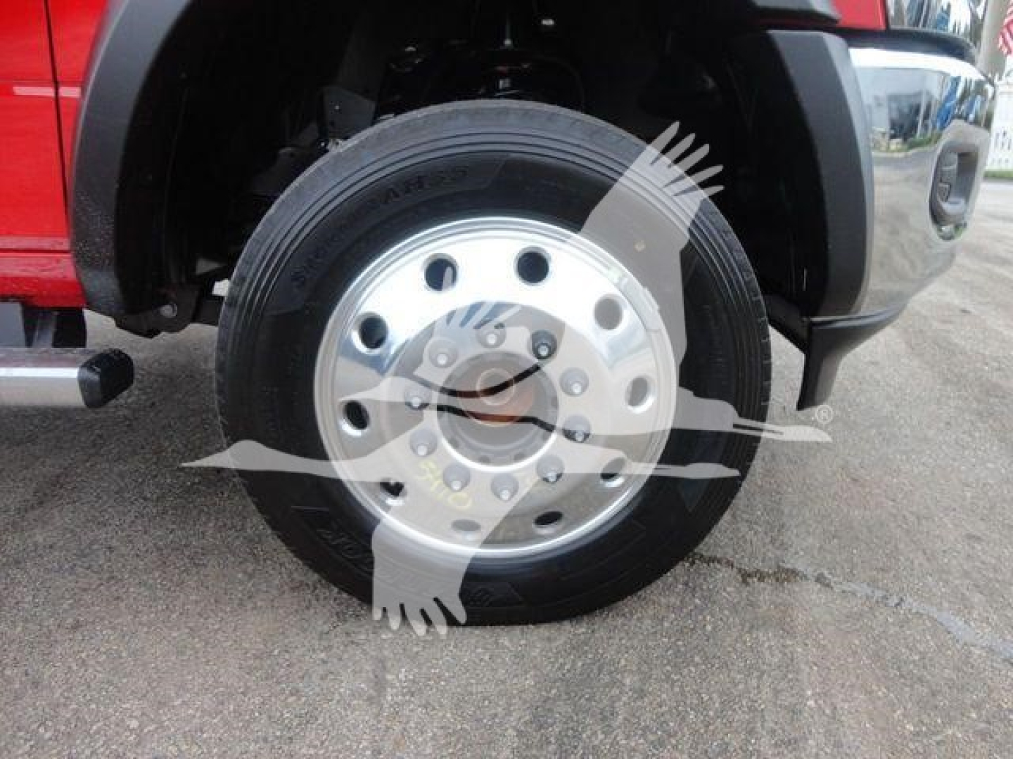 Wheel and tire on a Ram 5500 front left wheel well with a chrome hub and lug nuts. Partial fender and bumper visible.