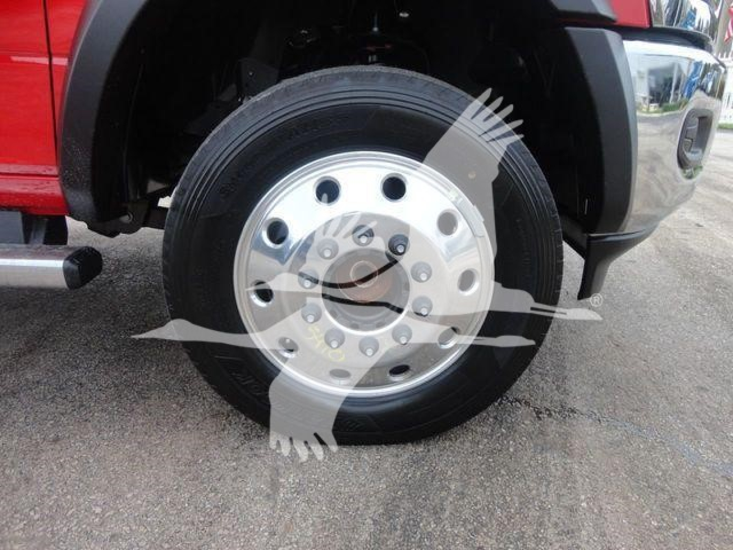 Ram 5500 front wheel showing polished steel hub with multiple lug studs and black tire, near fender and step bumper.