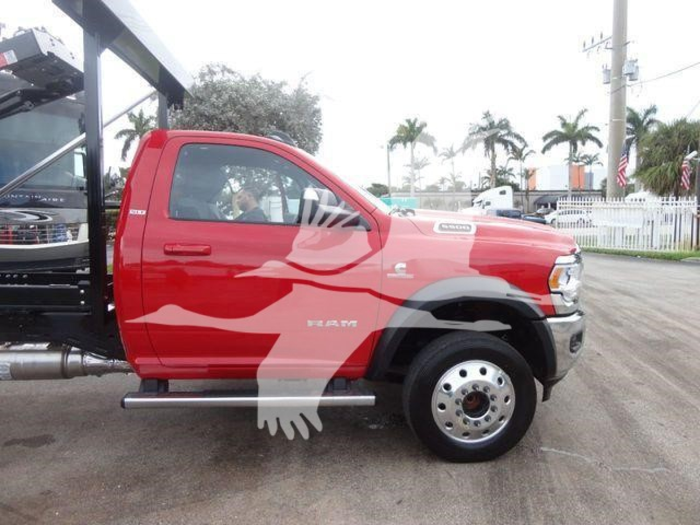 Red Ram 5500 truck in profile view with hooklift equipment, single cab, chrome side steps, and front wheel visible.