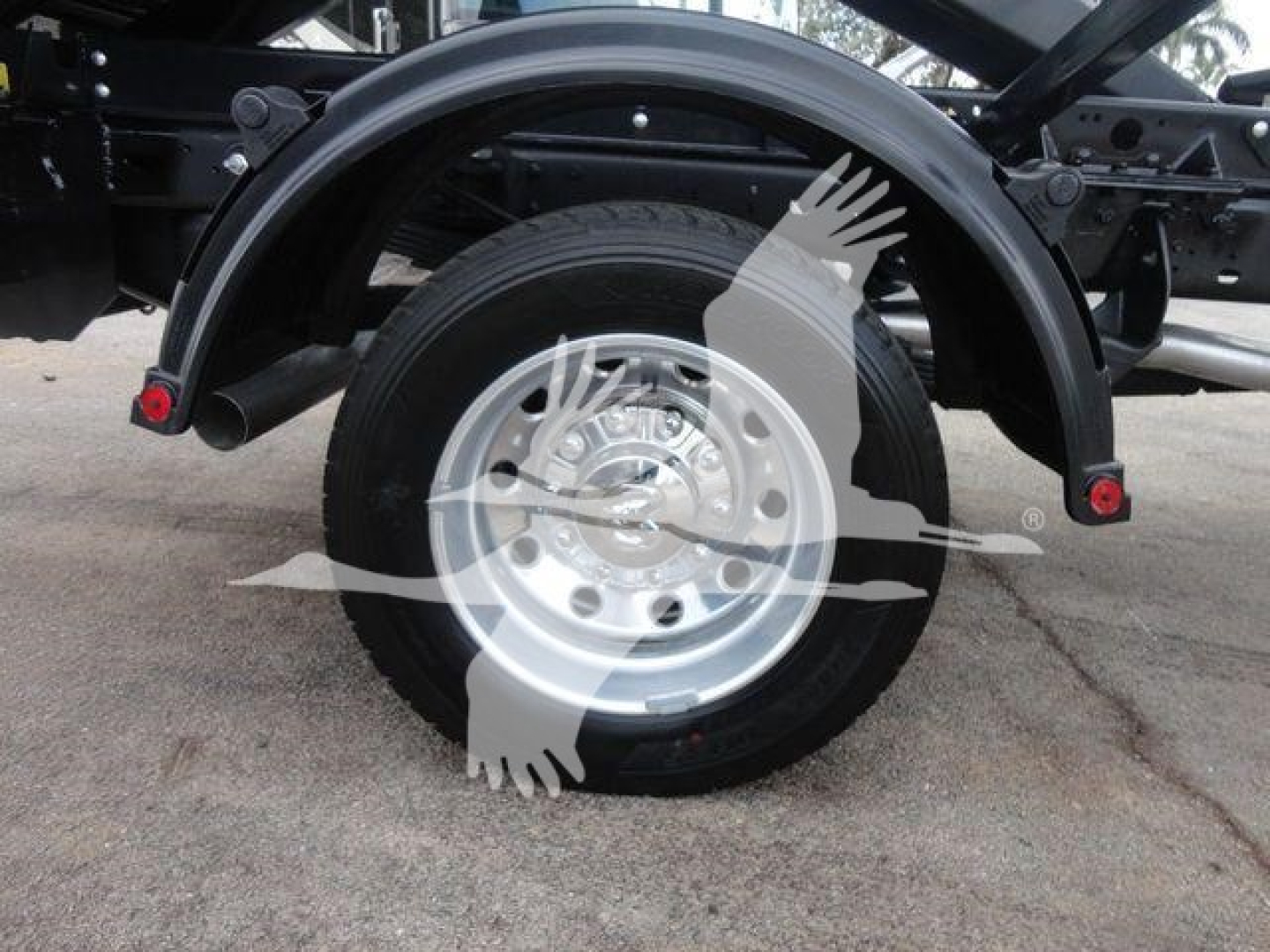 Ram 5500 truck rear wheel and fender area with hooklift frame and wheel well visible.
