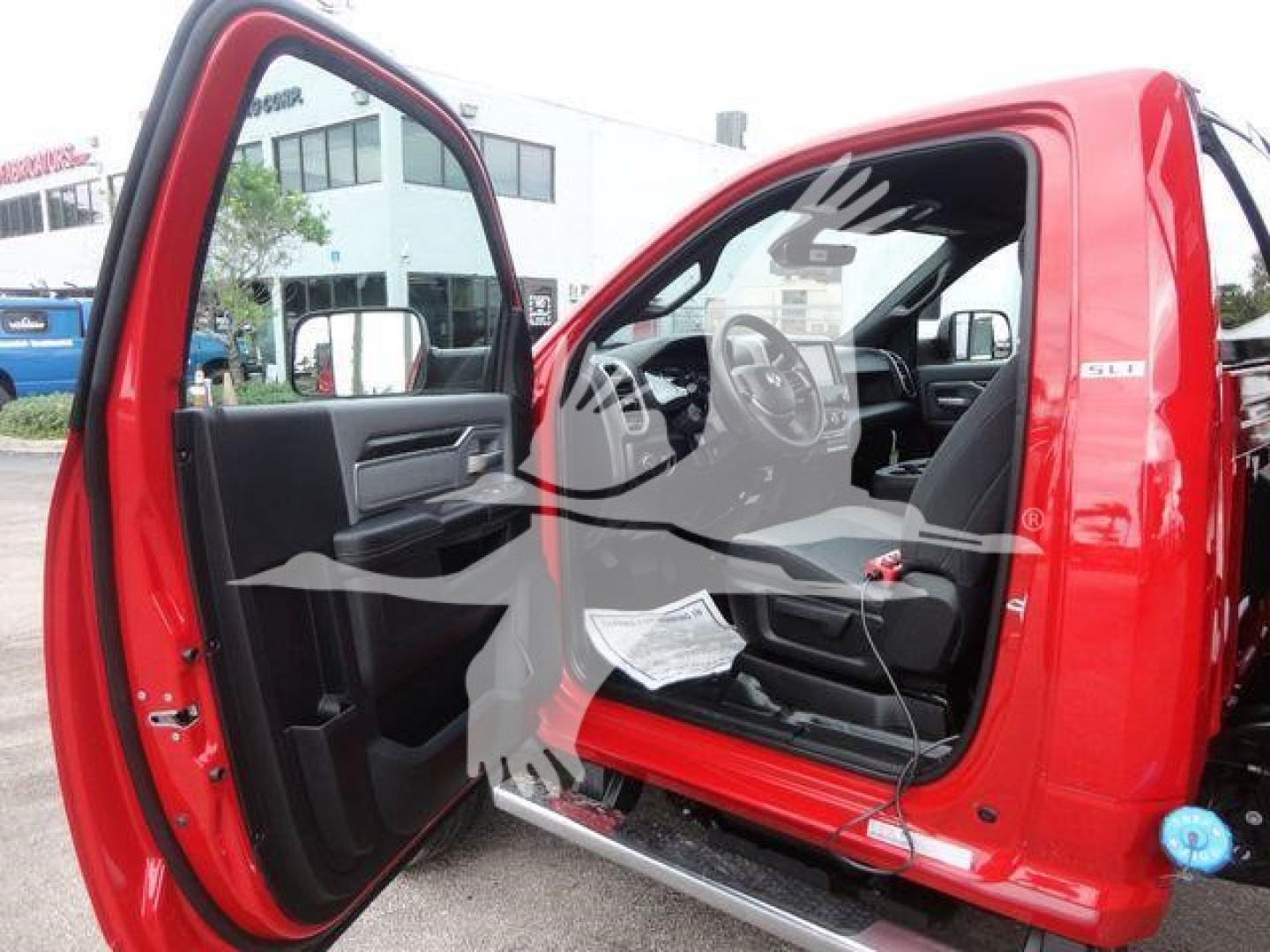 Ram 5500 SLT cab interior and open door showing steering wheel, dashboard, and driver's seat with red exterior.