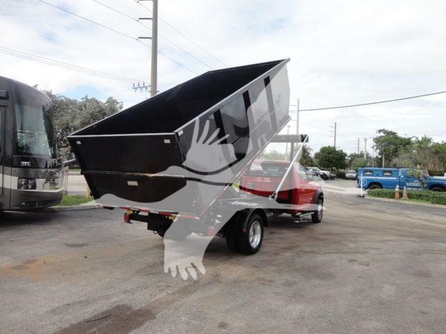 Ram 5500 SLT dump bed truck seen from rear-side showing dump bed raised on a hooklift setup.