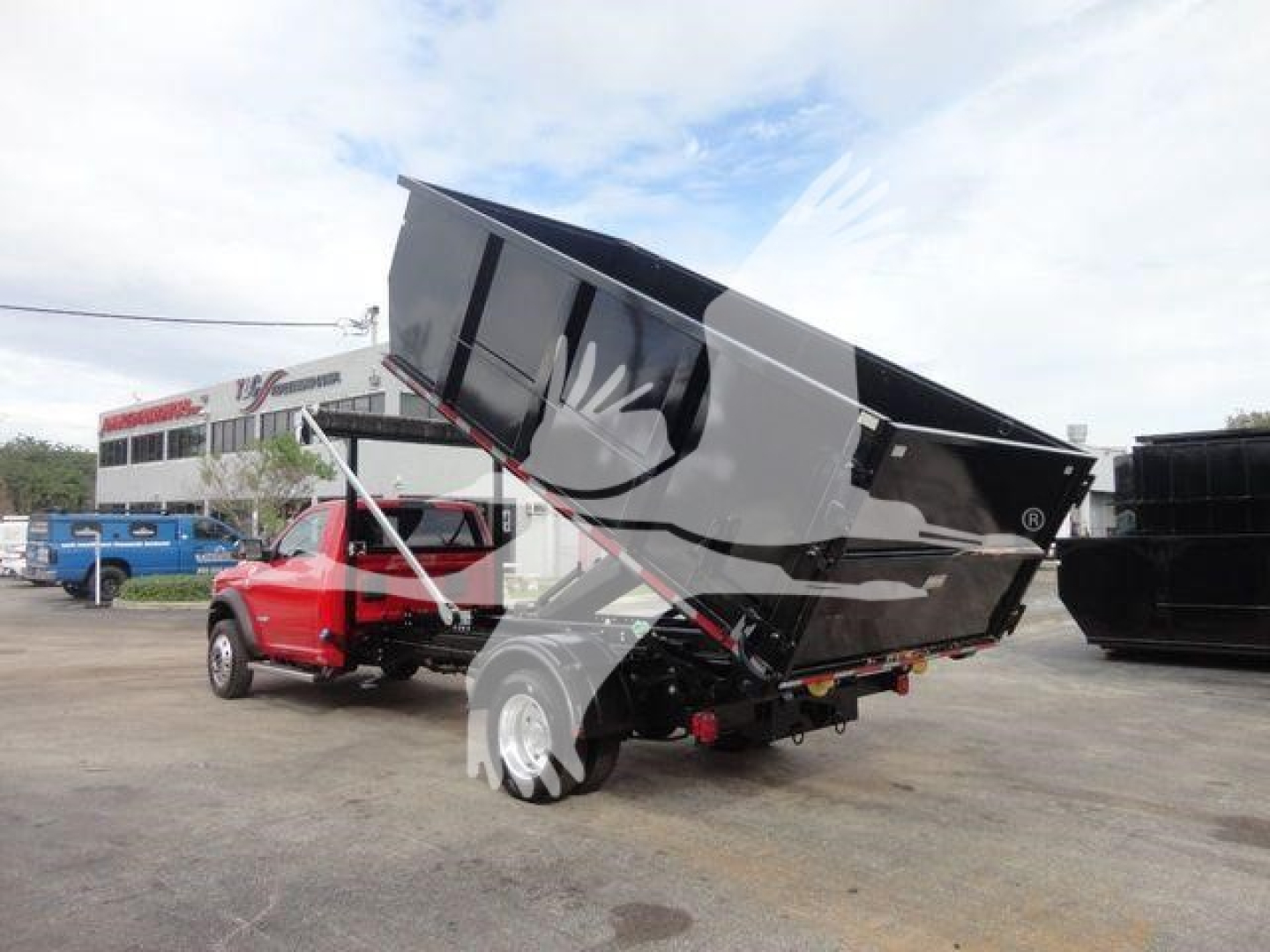 Ram 5500 SLT dump bed raised showing hydraulic hoses and bed support in a truck lot.