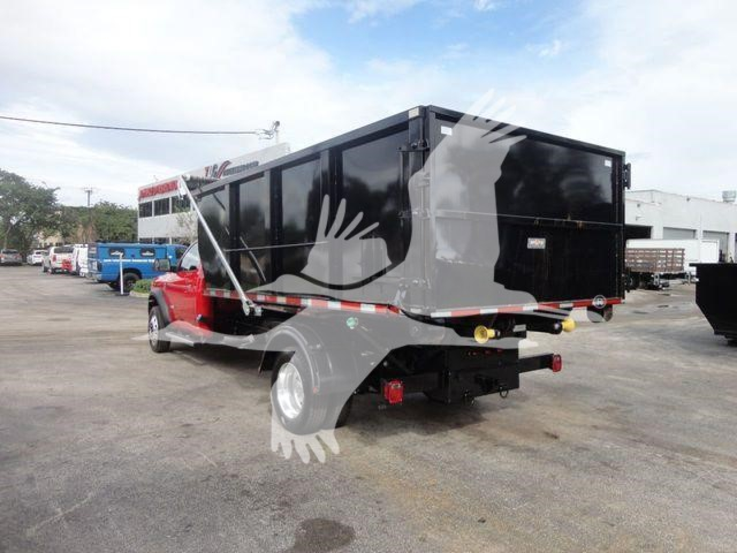 Ram 5500 SLT dump truck rear/side view showing large black dump bed and hitch with reflective tape.