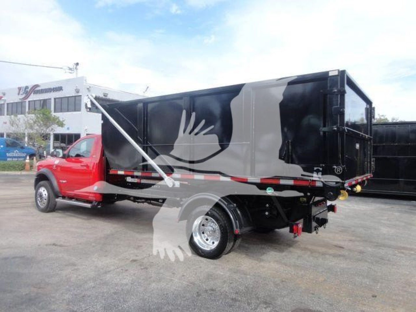 Ram 5500 SLT dump truck in black and red with decorative bird graphic, side view showing dump bed and rear hitch.