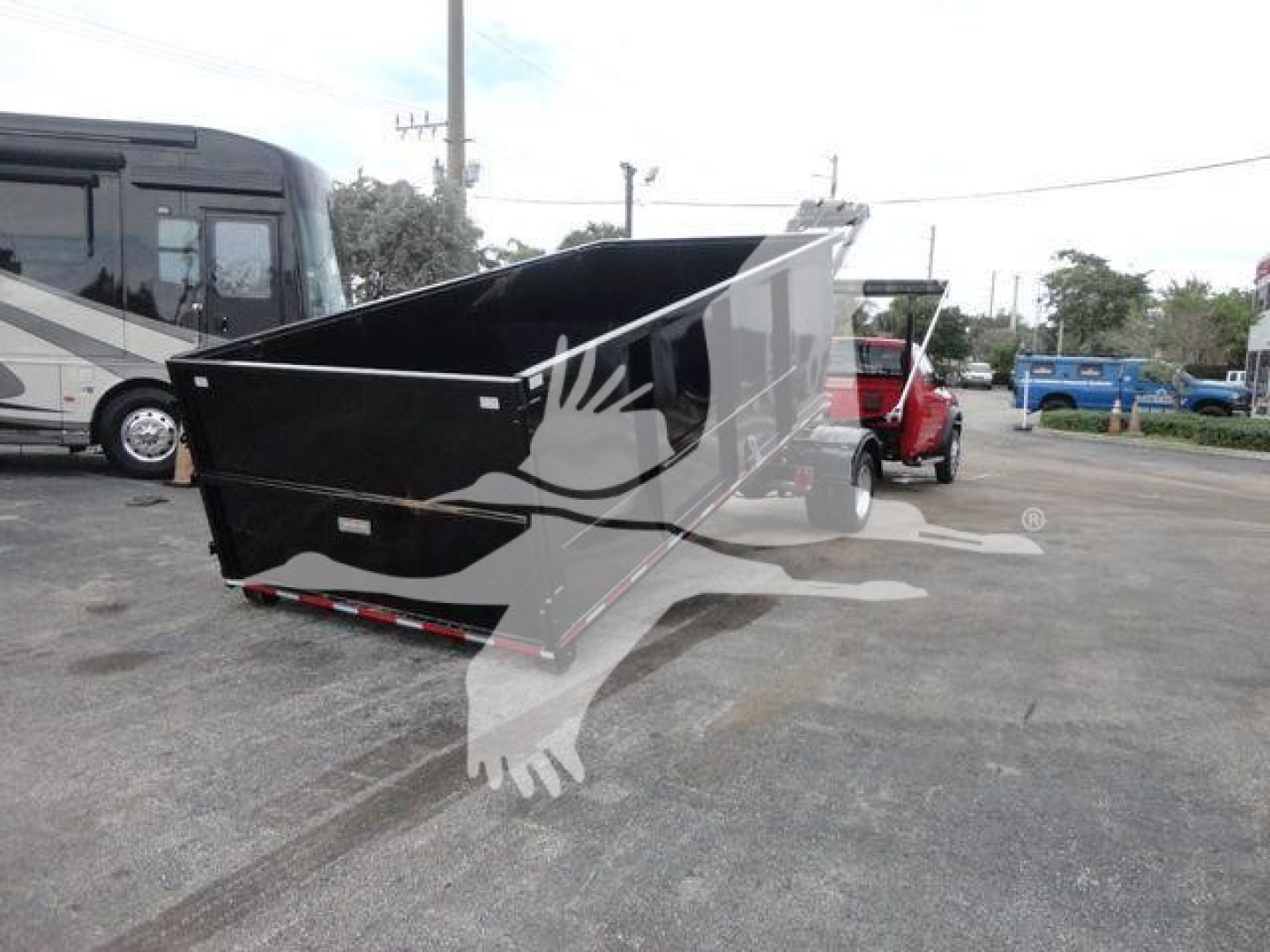 Dump bed on a Ram 5500 SLT hooklift truck in a dealership lot, black bed with raised sides and reflective surface details.