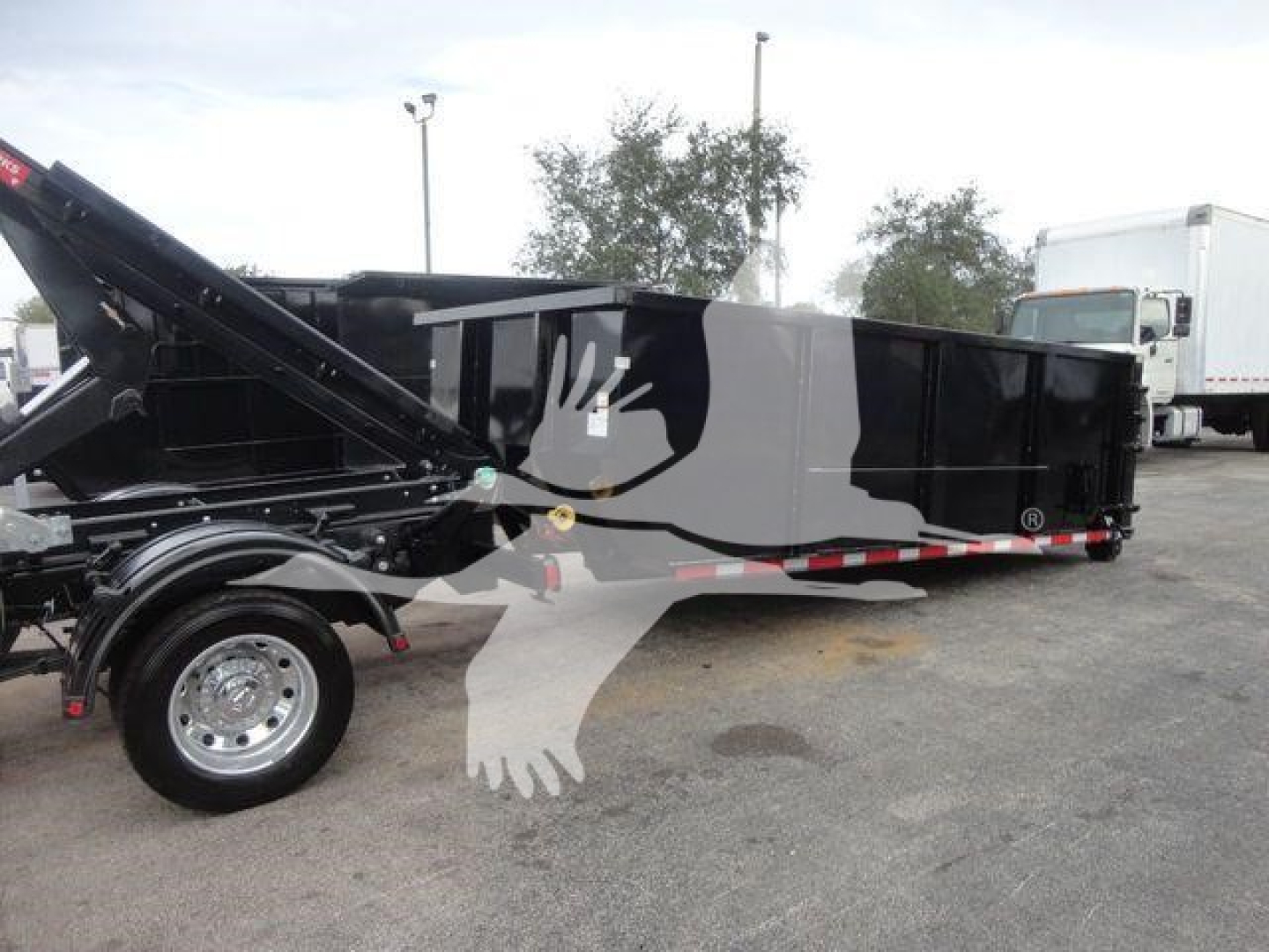 Ram 5500 SLT hooklift truck with black dump body and raised hydraulic arm; visible text includes no legible logos or brand text on the side in this image.