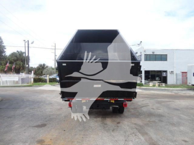 Dump bed/truck hitch showing rear view of a black metal dump body on a Ram 5500 truck with a hooklift, tail lights visible, open top edge.