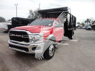 Ram 5500 dump truck in red and black, front three-quarter view, logo on grille, heavy-duty truck with dump bed visible