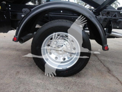 Ram 5500 truck rear wheel and fender area with hooklift frame and wheel well visible.