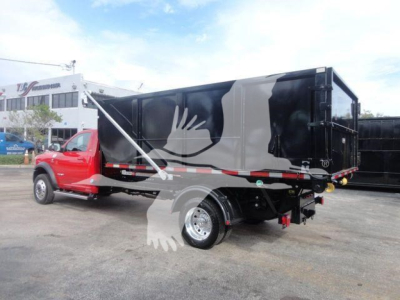 Ram 5500 SLT dump truck in black and red with decorative bird graphic, side view showing dump bed and rear hitch.