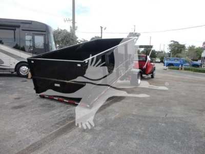 Dump bed on a Ram 5500 SLT hooklift truck in a dealership lot, black bed with raised sides and reflective surface details.