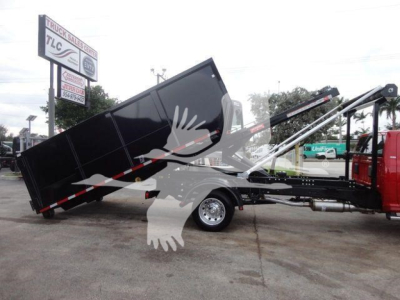 Truck bed with a hooklift system on a Ram 5500 SLT in-service showing hydraulic arms and a tilted dump bed.