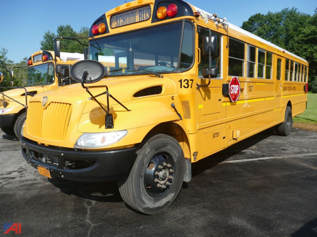 Yellow IC Corporation CE 3000 school bus front-left view with stop sign and bus number 137 visible.