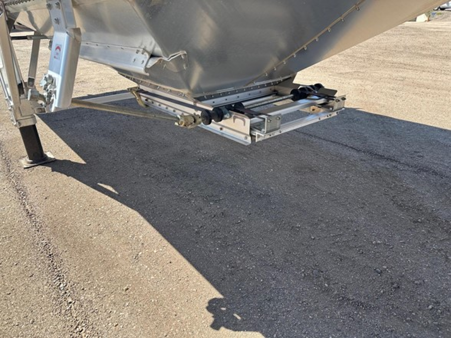Timpte Super Hopper trailer underside with landing gear and support brackets visible, showing silver chassis and bolted framework.