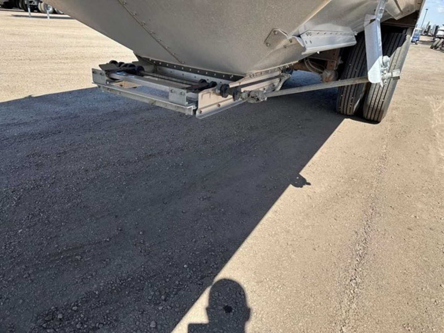 Hopper trailer rear view showing underside and suspension of a Timpte Super Hopper W trailer with metal frame and wheels visible.