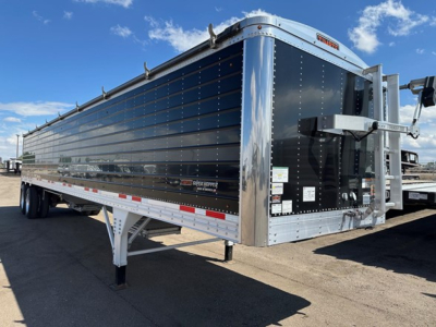 Timpte Super Hopper W trailer showing polished metal sides and front nose with landing gear and hitch area visible.