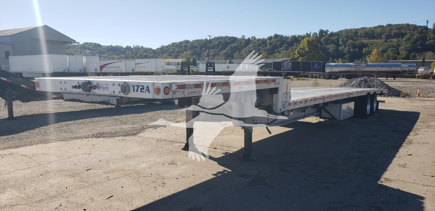 Manac aluminum dropdeck trailer in a road yard showing 172A marking and flatbed surface.