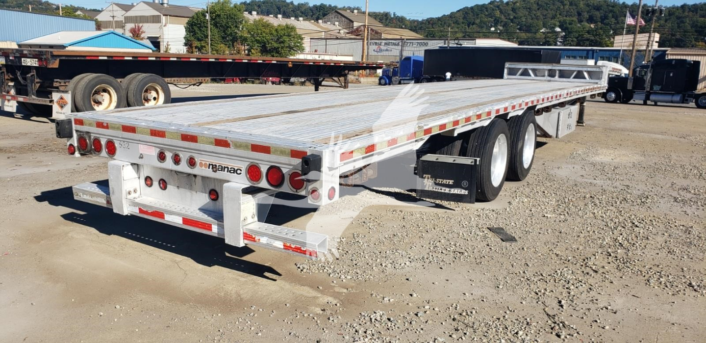 Manac aluminum dropdeck trailer side and rear showing load deck, wheels, and rear bumper with taillights; visible brand 'manac' on rear guard.