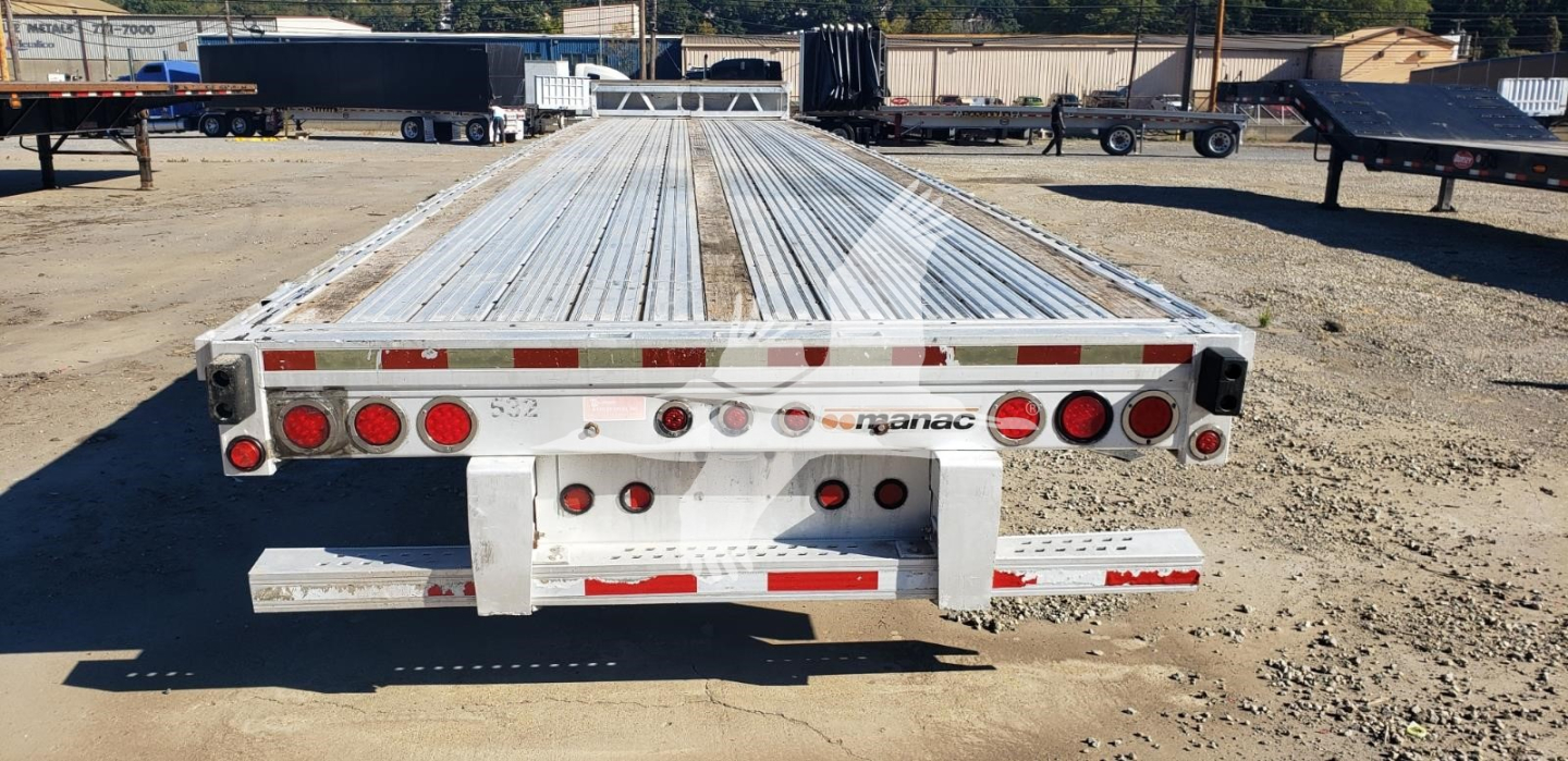 Manac aluminum dropdeck trailer rear view showing multiple red taillights and reflective tape along back edge.