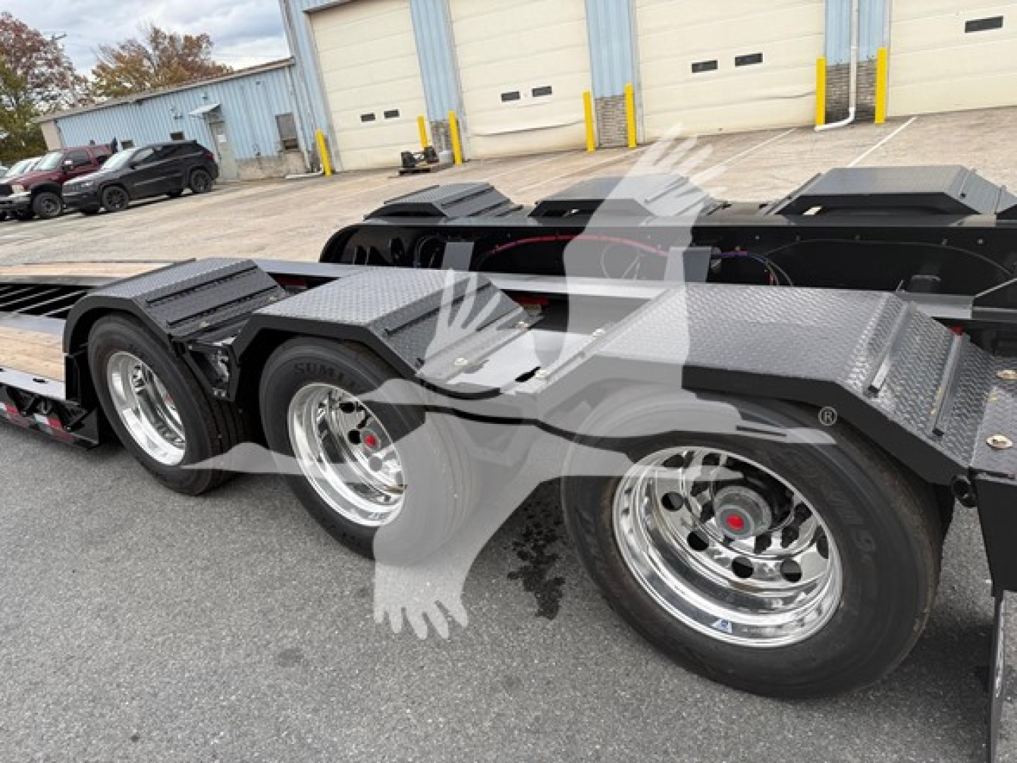 Fontaine Workhorse 55 LCC trailer chassis showing dual rear axles with polished chrome wheels and black diamond plate fenders.