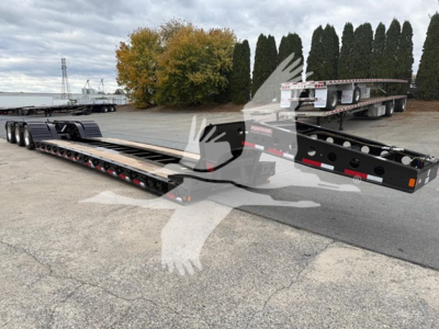 Fontaine Workhorse 55 Lcc lowboy trailer showing long gooseneck deck and flatbed sections with rear ramps and spare wheel; trailer in lot with trees in background.
