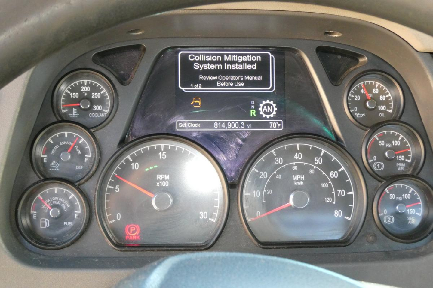 Peterbilt instrument cluster and central display showing dashboard gauges and a message about Collision Mitigation System installed.