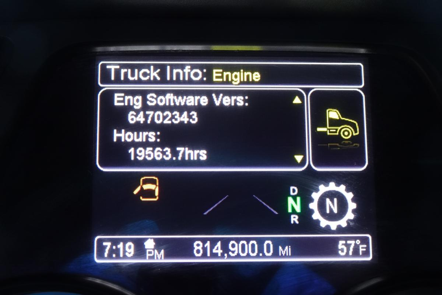 Peterbilt 579 instrument cluster showing engine info, hours 19563.7, miles 814,900, time 7:19 PM, outside temp 57F, gear indicator D N R, navigation icon.