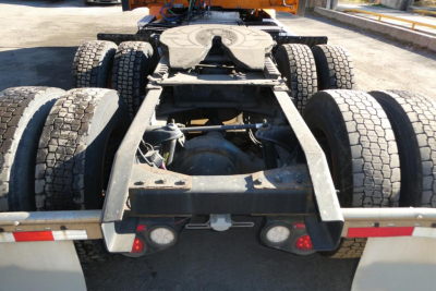 Peterbilt truck chassis rear view showing fifth wheel, suspension, drive axles and dual rear tires.
