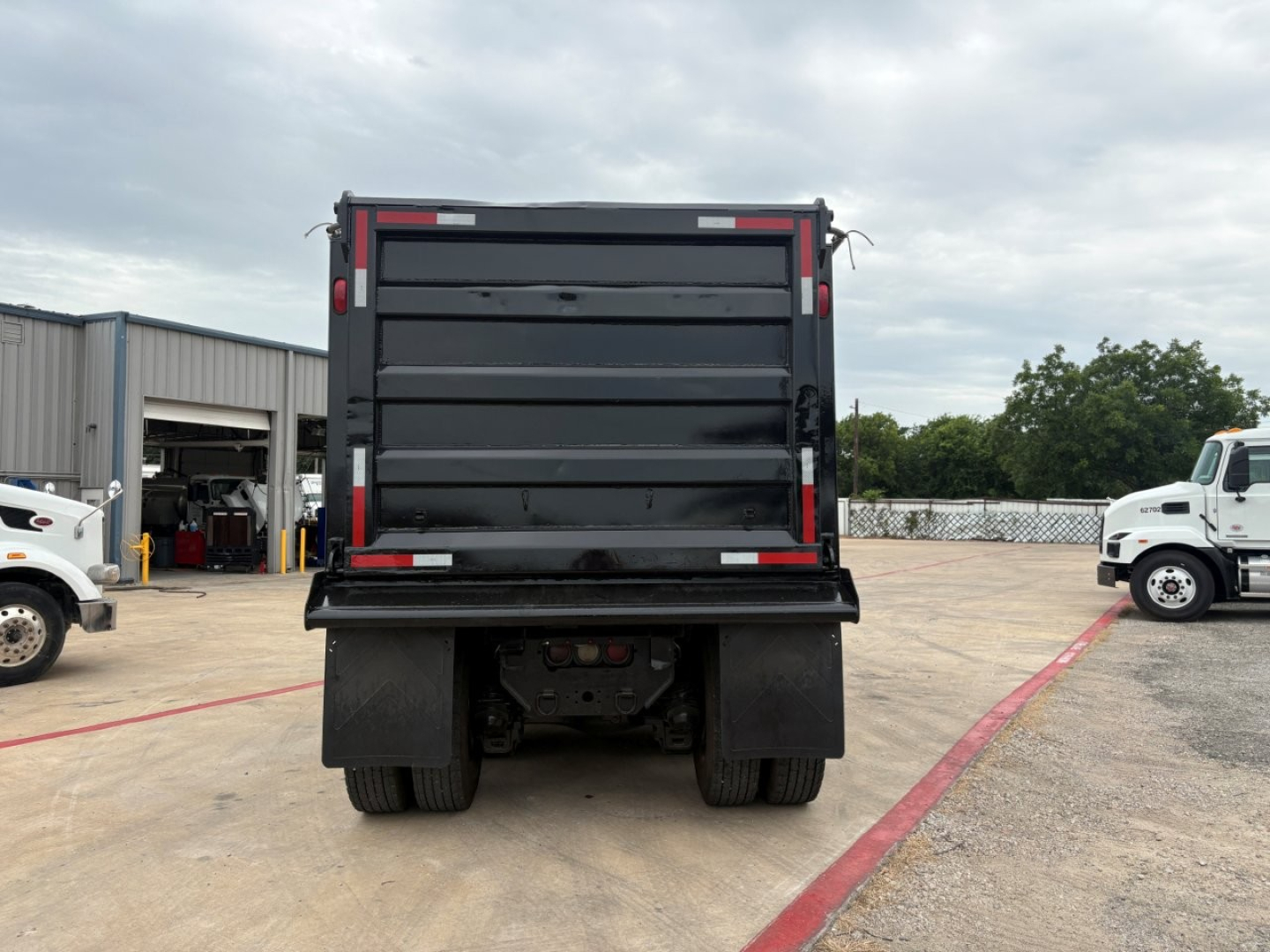 Dump truck rear view showing dump bed and taillights on a 2020 Mack GR64F in-service condition.