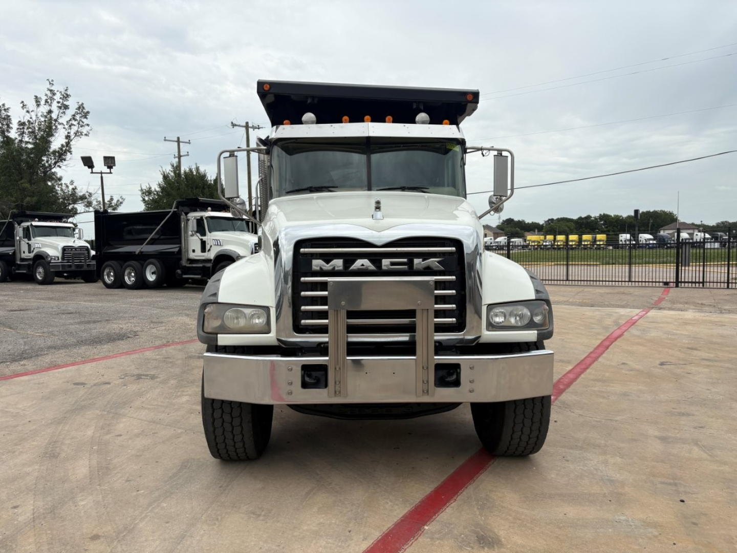 Front view of a white 2020 Mack GR64F dump truck showing the grille with MACK letters and bumper guard.