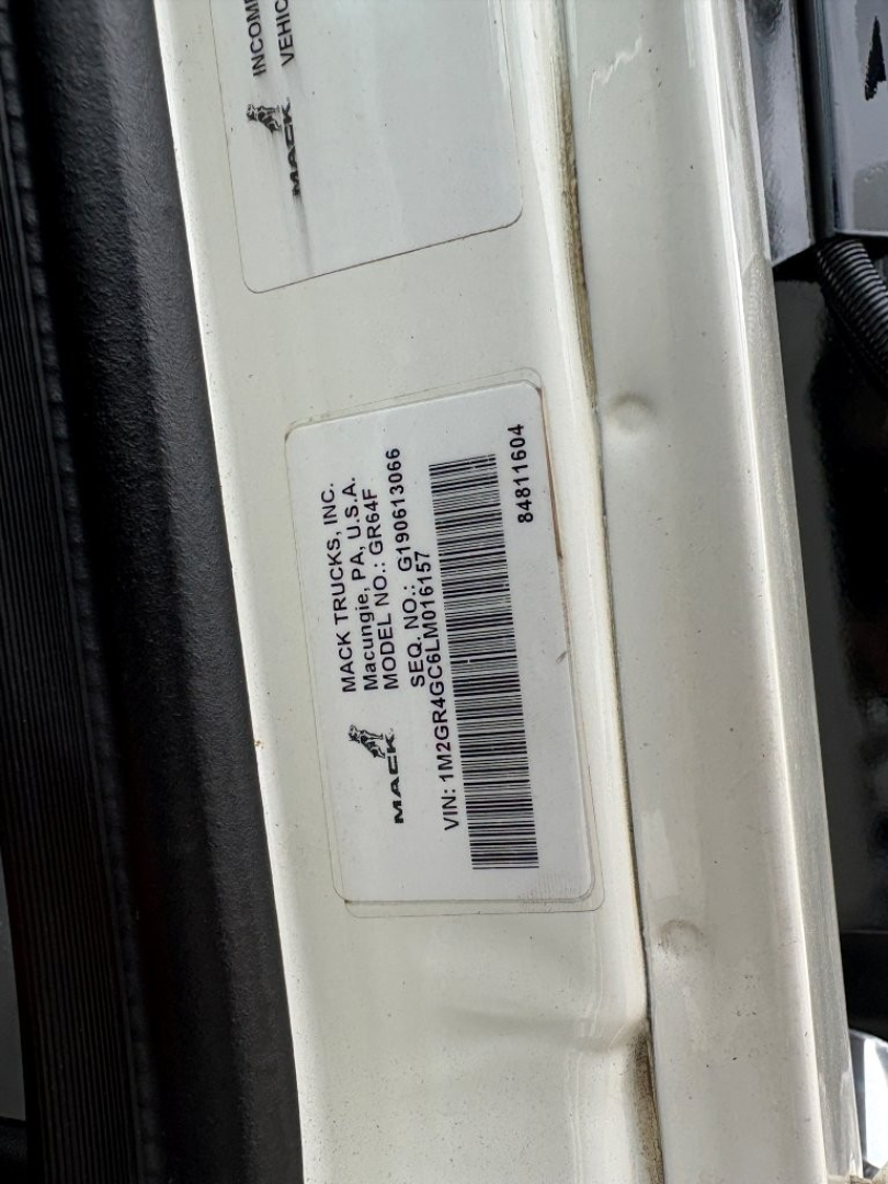 Label on Mack truck door frame showing VIN and model details including 'MACK TRUCKS INC', 'MODEL MD6', 'VIN: 1M2GR4GC6LM016157' and barcode sticker.