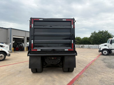 Dump truck rear view showing dump bed and taillights on a 2020 Mack GR64F in-service condition.