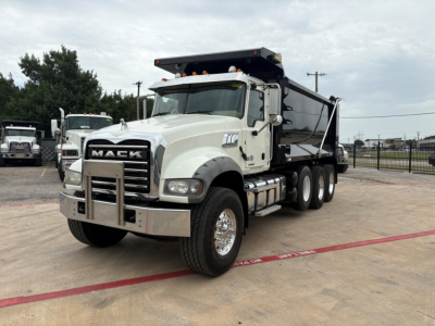 Dump truck with Mack grille showing front view of a 2020 Mack GR64F dump truck, white cab, black dump bed, multiple wheels, stock number B3427P.