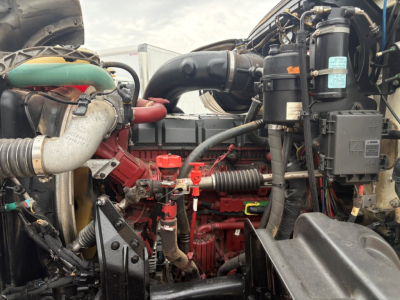 Engine bay of a 2020 Mack GR64F dump truck showing red engine block, hoses, air intake, and hydraulic components with various labels.