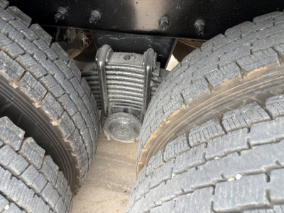 Mack GR64F rear axle center view showing differential housing between dual rear tires and suspension components.